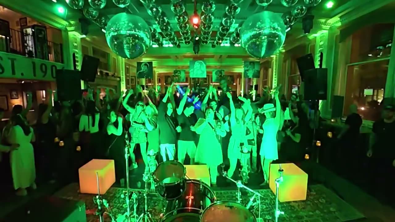 Crowd dancing under green lights